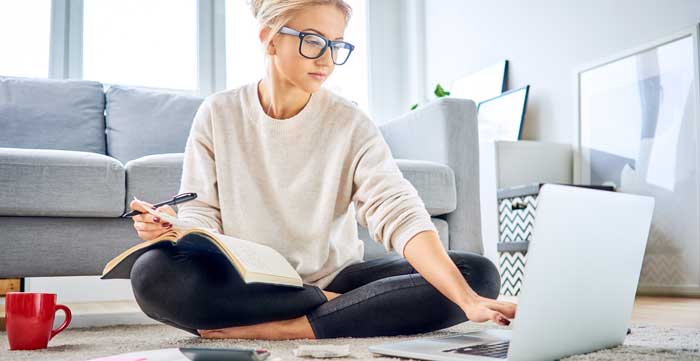 girl working on the computer sitting on the floor