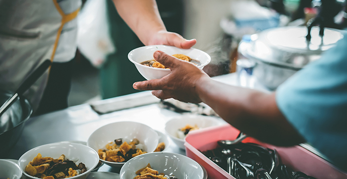 volunteer serving soup in a line