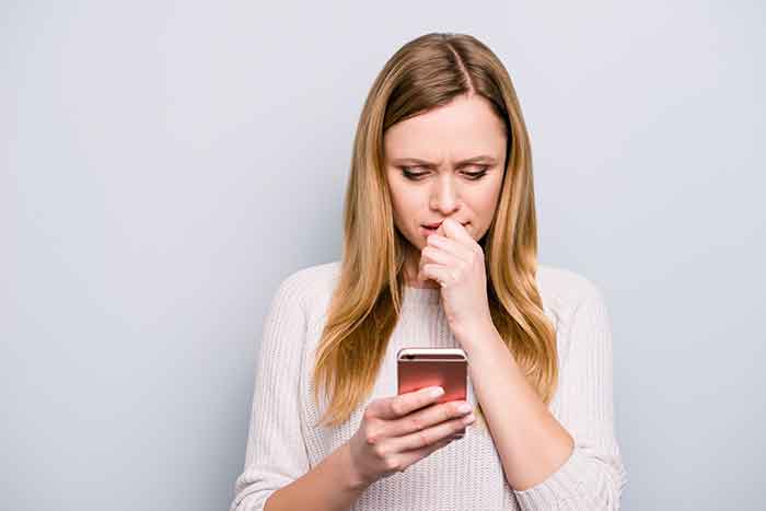 woman looking at her phone with concern