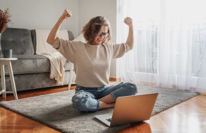 woman celebrating in front of her computer